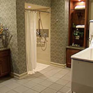 A modern bathroom featuring a walk-in shower, tiled flooring, and elegant cabinetry.