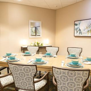 A well-decorated dining room with a neatly set table and elegant chairs.