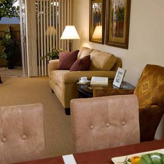 A cozy living room with a sofa, dining table, and warm lighting.