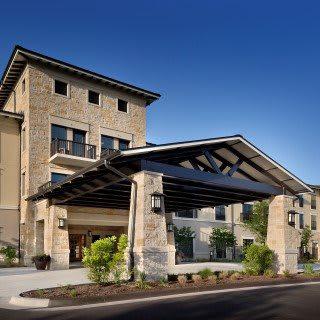 A modern hotel building with a stone facade and main entrance.