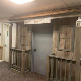 Rustic wooden facade with a central doorway and shuttered windows, evoking a themed decor.