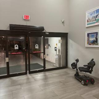 A view of the entrance featuring automatic doors and a mobility scooter parked nearby.