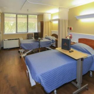 A hospital room with two neatly arranged patient beds and medical equipment.