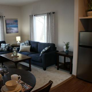 Cozy living room with a sofa, coffee table, and dining area.