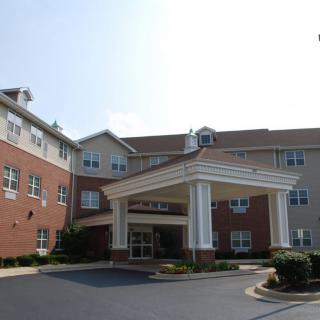 The image shows the front entrance of a multi-story building with a porte-cochre.