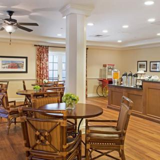 A cozy dining area with wooden tables and chairs, complete with a beverage station.