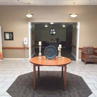 A well-lit foyer featuring a round table with decorative candles and a tray.
