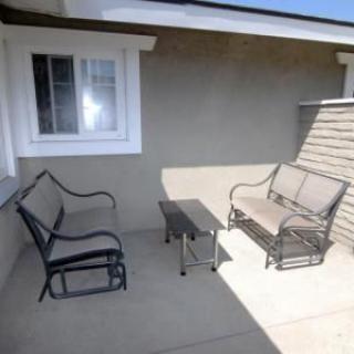A sunny outdoor patio with comfortable seating and a small table.