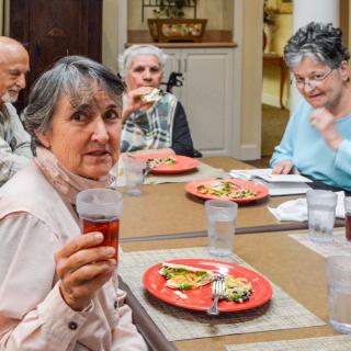A group of seniors enjoying a meal together at a dining table.