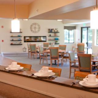 A modern and bright dining room with neatly arranged tables and chairs, featuring contemporary decor.