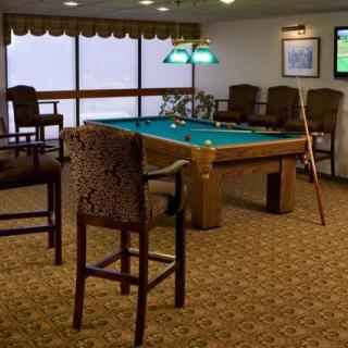 A cozy game room with a pool table and seating area.