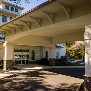 A view of a building entrance featuring a large canopy and modern architectural design.
