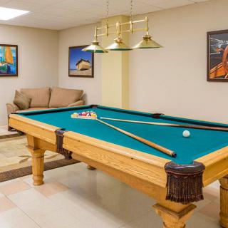 A cozy game room featuring a billiards table and comfortable seating.