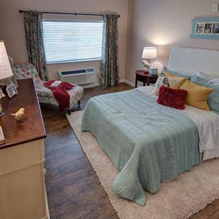 A cozy bedroom with a neatly made bed, bedside lamps, and stylish decor.
