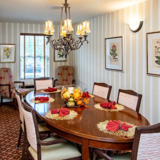 A beautifully arranged dining room featuring a wooden table, elegant chandelier, and tasteful decorations.