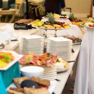 A lavish buffet setup with various dishes and neatly stacked plates.