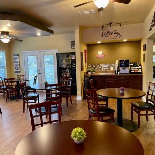 A cozy cafe interior with wooden furniture and warm lighting.