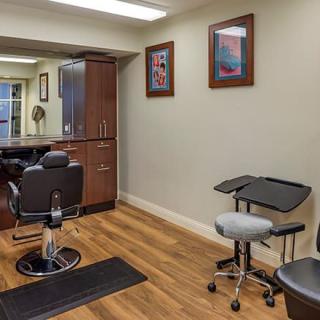 A well-organized salon interior featuring barber chairs, mirrors, and artwork on the walls.