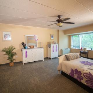 A serene and spacious bedroom featuring a comfortable bed, stylish furniture, and natural light.