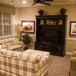 A cozy living room with plaid sofas and a large entertainment center.