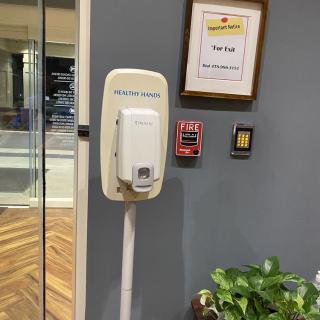 Wall-mounted hand sanitizer dispenser in an office setting.