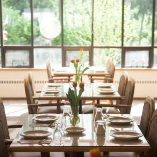 A well-lit restaurant dining area with neatly arranged tables and chairs.