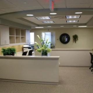A modern reception area with plants and office furniture.