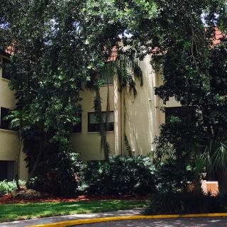 A residential building surrounded by lush greenery and trees.