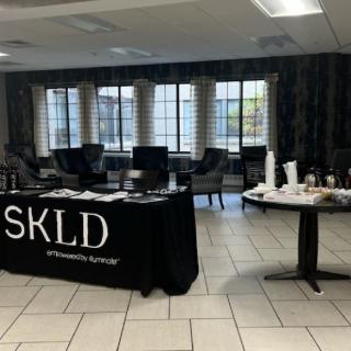 A lobby area with a reception table displaying brochures and a nearby coffee station.