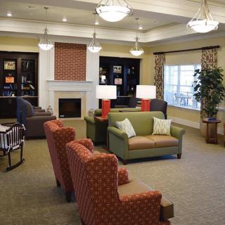 A cozy living room with comfortable seating, a fireplace, and elegant lighting.
