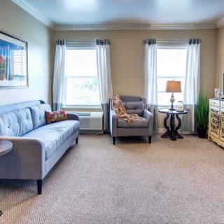A cozy living room with modern furniture and large windows.