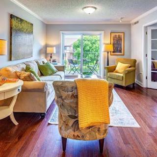 A bright and inviting living room featuring comfortable seating, natural light, and modern decor.