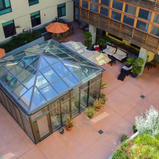 Aerial view of a courtyard featuring a glass-enclosed structure with surrounding seating areas.