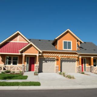 A modern duplex with a vibrant exterior located in a suburban neighborhood.