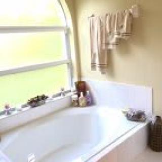 A cozy bathroom with a bathtub and neatly arranged towels hanging from the wall.