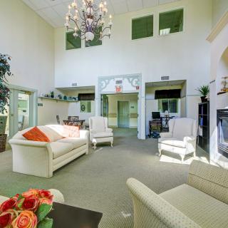 A spacious and well-lit living room with modern furniture and a chandelier.