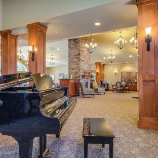 A spacious lobby featuring a grand piano and elegant furnishings.