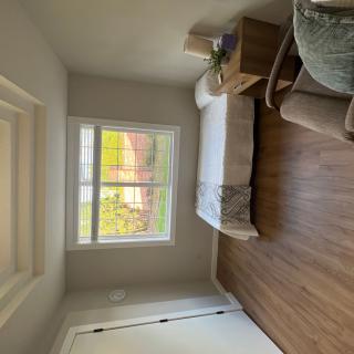 A minimalist bedroom with a large window allowing natural light in.