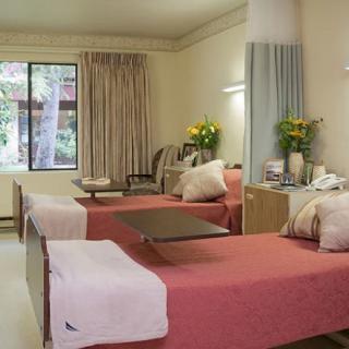 A hospital room with two neatly made beds, featuring a comforting and welcoming atmosphere.