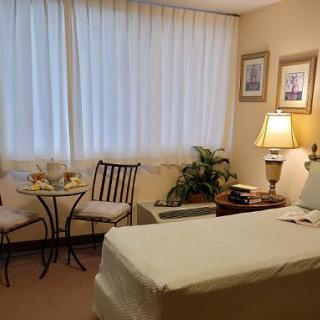 A cozy treatment room featuring a massage table, seating area, and warm decor.