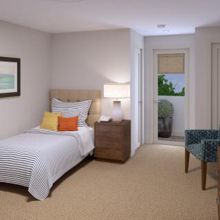 A cozy bedroom with a single bed, bedside table, and armchair.
