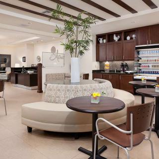 A modern, cozy lounge with comfortable seating and a refreshment area.