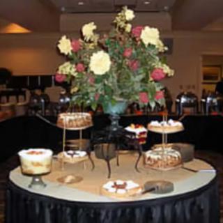 A beautifully decorated dessert table featuring various cakes and a floral centerpiece.