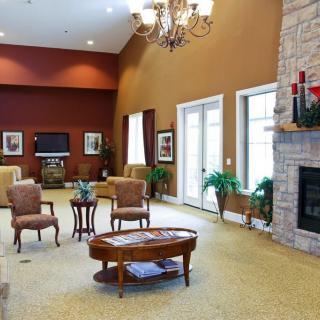 A cozy living room with comfortable seating, a fireplace, and a chandelier creating a warm atmosphere.