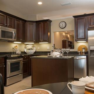 A modern kitchen with dark wood cabinets and stainless steel appliances.