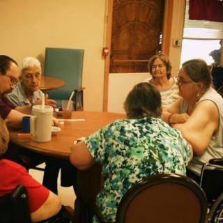 A group of people gathered around a table for a discussion indoors.