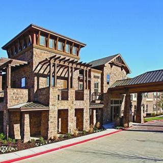 A modern stone building with an intricate entrance design under a clear blue sky.