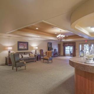 A spacious lobby with elegant furniture and a chandelier.