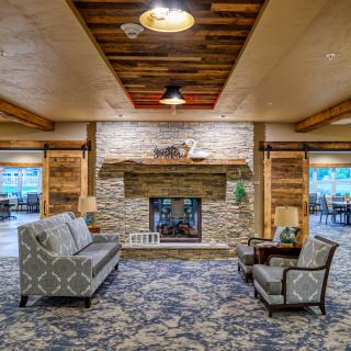 A cozy living room with a stone fireplace and elegant seating.