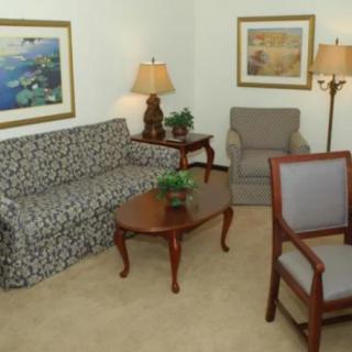 A cozy living room with a patterned sofa, chairs, and a wooden coffee table.